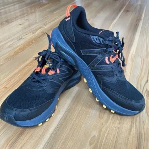 Black and orange New Balance tennis shoes